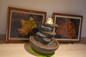 Ein Zimmerbrunnen, bei dem sich eine Kristallkugel auf aufgeschichteten flachen Steinen dreht